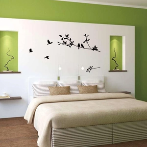 Detail of minimalist black bird and branch silhouettes wall decals on a bedroom wall