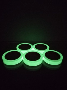 Five rolls of luminous glow-in-the-dark safety warning tape with green neon light effect