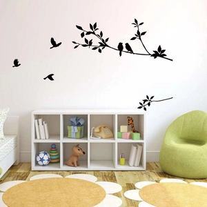 Detail of matte black bird and tree branch silhouette wall stickers in a modern kids room