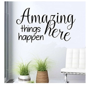 Close-up of Amazing Things Happen Here vinyl wall decal in a modern living room