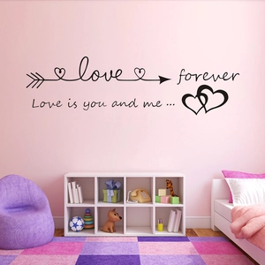 Close-up of LOVE forever wall sticker with arrows and hearts on a nursery wall