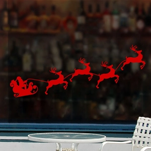 Detail of red Santa sleigh and reindeer silhouette window sticker on glass surface