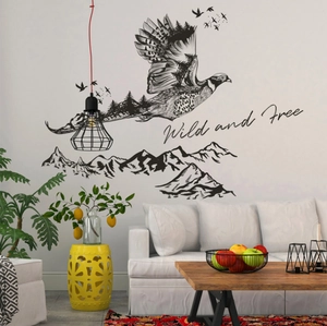Ink eagle wall decal with forest silhouette and Wild and Free slogan on white wall