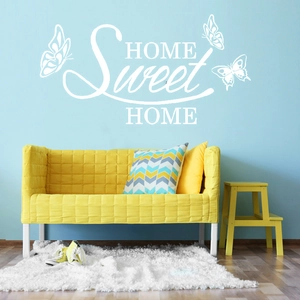 Dettaglio dell'adesivo murale bianco 'HOME Sweet HOME' con decoro di farfalle