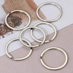 Set of seven polished silver flat metal key rings displayed on a decorative background