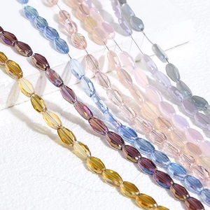 Colorful faceted oval glass beads for DIY jewelry making displayed on a stone surface