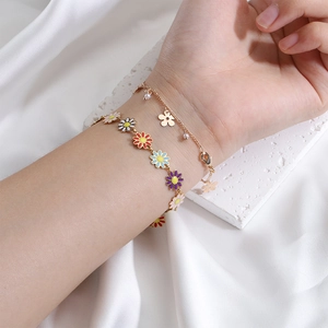 Bracciali sovrapposti placcati in oro con ciondolo a fiore e margherite in smalto colorato