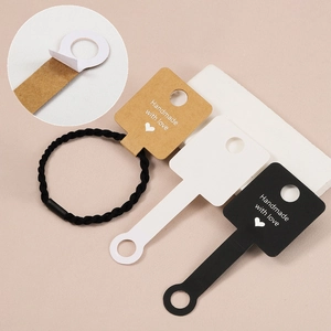 Adhesive jewelry display cards in kraft, black, and white for bracelets and hair ties