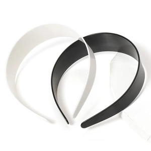 Cerchietti larghi minimalisti in plastica bianca e nera su sfondo bianco pulito