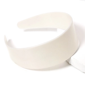 Cerchietto largo in resina opaca color crema esposto su un supporto geometrico moderno