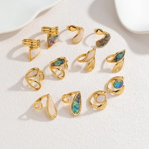 Flat lay of geometric 18k gold irregular rings with inlaid shell and abalone textures