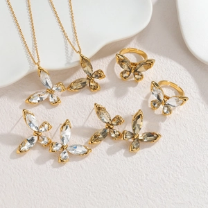 Detailweergave van een gouden vlinder sieradenset met kettingen ringen en oorbellen
