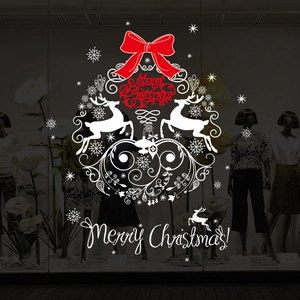 Close-up of Christmas window decal featuring white reindeer and a large red bow decoration