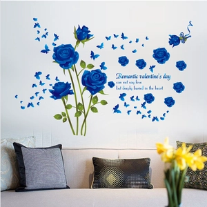 Detailed blue rose and butterfly wall stickers applied above a sofa in a living room decor