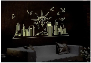 Luminous wall sticker of New York skyline and Statue of Liberty in a dark bedroom setting