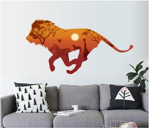 Lion silhouette wall decal with African savanna sunset theme over a grey fabric sofa