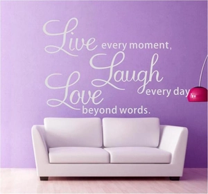 Live Every Moment wall sticker with butterflies for home decor above a white sofa