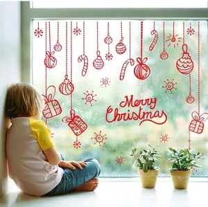 Christmas window decals with red ornaments, snowflakes and reindeer on a warm glass window