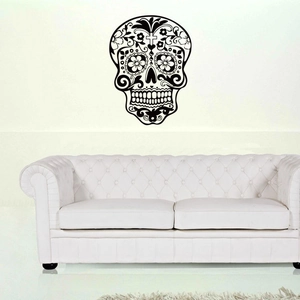 Decorative black skull wall decal in Day of the Dead style above a white sofa