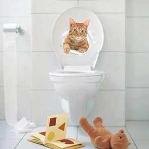 Detail of 3D orange tabby cat wall sticker with broken paper effect on a white toilet lid