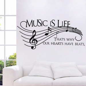 Music Is Life wall decal with musical notes and staff on white wall over sofa
