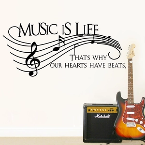 Musical notes wall decal with 'Music is Life' quote on white wall near guitar amp