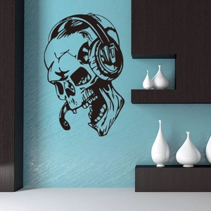 Detail of skull with headphones wall sticker on a blue wall with ceramic vases