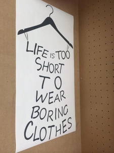 Close-up of Life Is Short wall sticker on a pegboard with coat hanger graphic