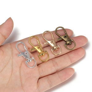 Set of swivel lobster claw clasps in four metallic finishes held in palm for scale