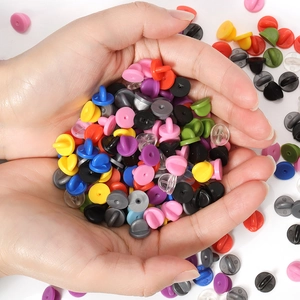 Assortimento di chiusure a farfalla colorate in gomma per spille e distintivi in mano