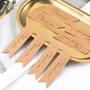 Brown kraft paper swallowtail gift tags with Thank You print in a gold tray