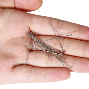 Polished stainless steel ball head pins for DIY jewelry making held in hand for scale