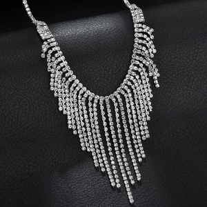 Elegant silver V-shaped tassel necklace with shiny rhinestones on black leather background