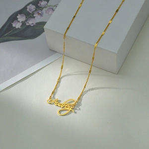 Golden personalized Audrey name necklace in stainless steel with floral art script
