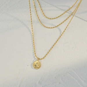 Collar de triple capa con cuentas doradas y colgante de Cupido sobre piedra