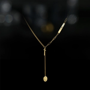 Dettaglio della collana a Y placcata oro 14K con ciondolo a croce e medaglia miracolosa
