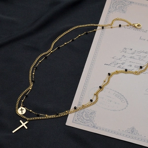 Dettaglio della collana a doppio strato placcata oro 14K con perline nere e croci