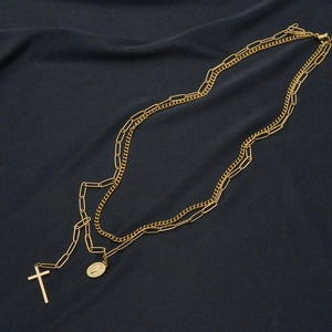 Dettaglio della collana a doppio strato in oro 14K con ciondoli a croce e moneta
