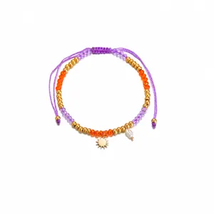 Detail of adjustable beaded bracelet with sun charm and irregular pearl showing 14-26cm length