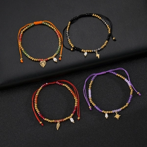 Handmade bead bracelets with gold pendants and pearls on a premium black leather background