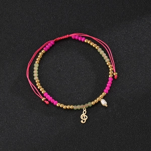 Detail of beaded bracelet with treble clef charm, pink beads and teardrop pearl pendant