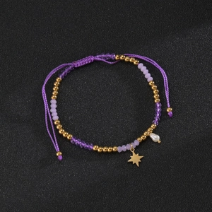 Detail of beaded bracelet with purple crystals, star charm and white pearl accent