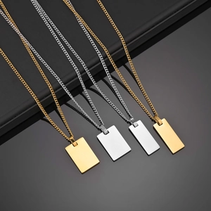 Polished gold and silver rectangular military tag necklaces on minimalist Cuban chains