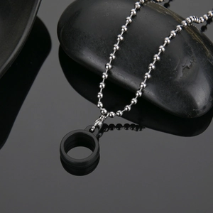 Detail of 304 stainless steel bead chain with black matte ring on black stone base