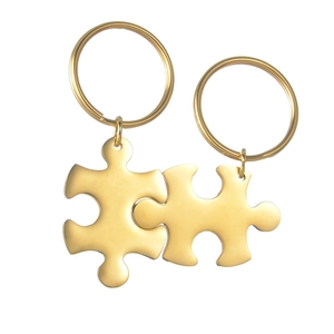 Polished gold puzzle piece keychains showing nested design and metallic finish