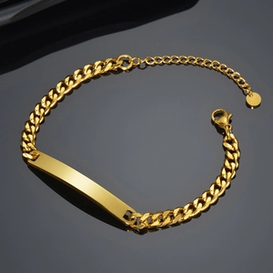 Macro view of gold stainless steel Cuban link bracelet featuring a polished ID plate