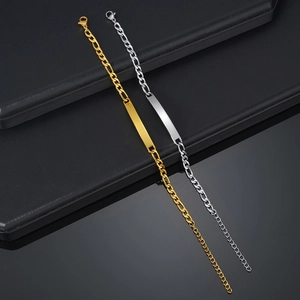 Detailed close-up of gold and silver Figaro link bracelets with polished metal plates