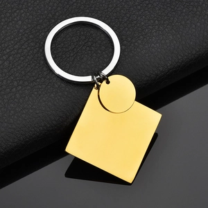 Gepolijste gouden vierkante en ronde hangers aan een zilveren sleutelhanger