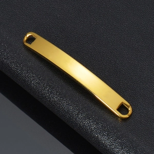Macro shot of a polished gold-plated curved bar charm for NK chain bracelets on black leather