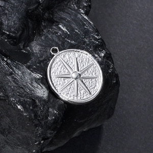 Pendentif étoile en acier inoxydable vintage avec texture martelée sur roche
